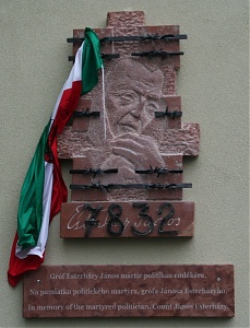 Komáromi domborművén a börtönben meggyötört arca, alatta a rabszáma és háromnyelvű felirat